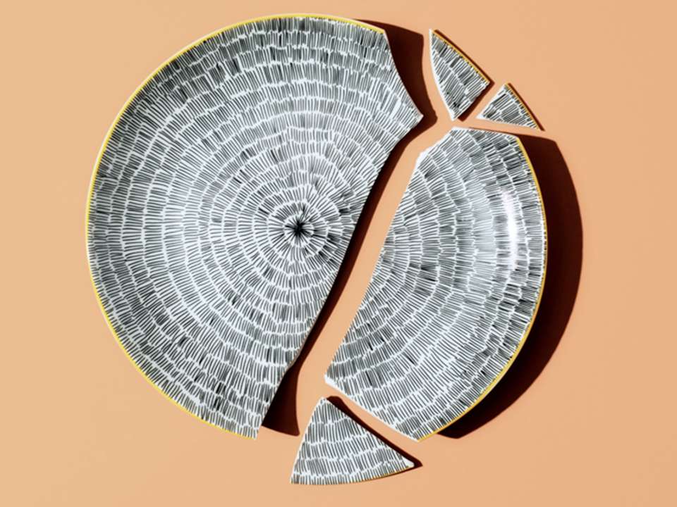 A patterned broken plate on a peach background.