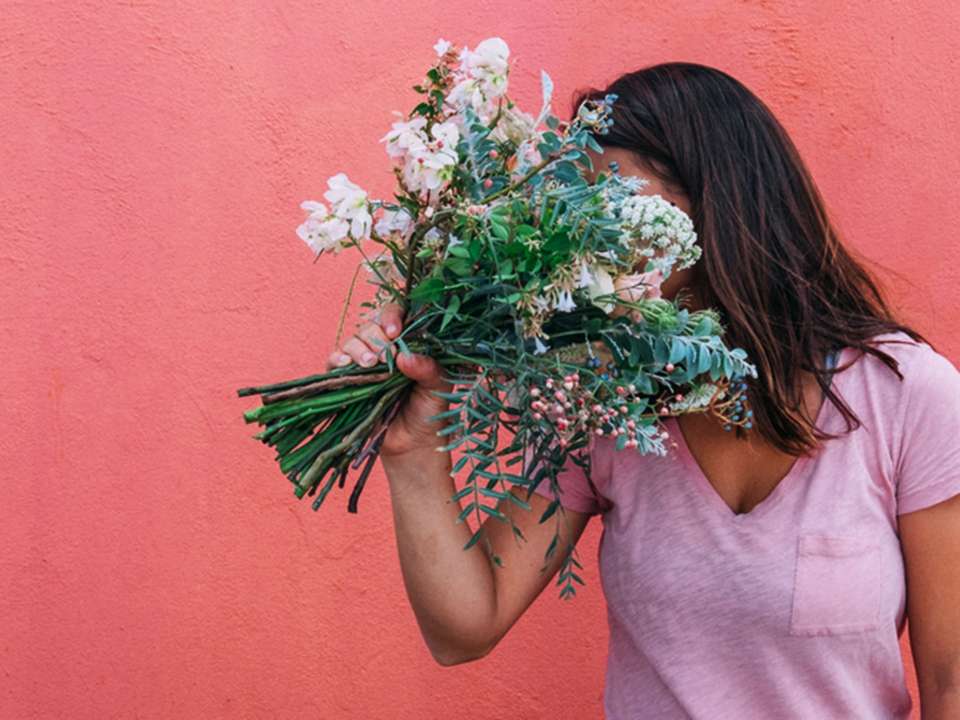 woman smelling a bouquet of flowers