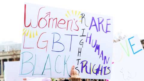 An activists's sign at a protest that supports women's rights, LGBTQ rights and black rights.