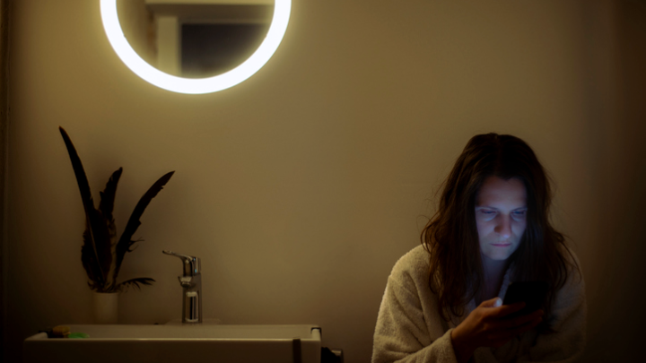 A woman in her bathroom at nighttime
