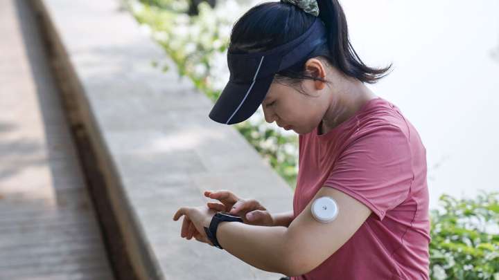 A woman checks her blood sugar reading on her smartwatch.