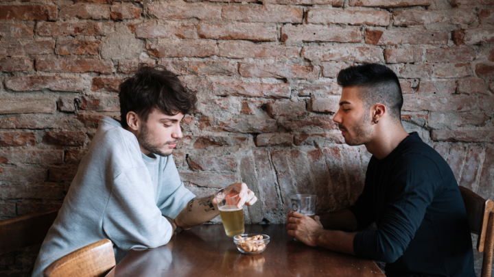 A photo of two men sitting at a table in a restaurant