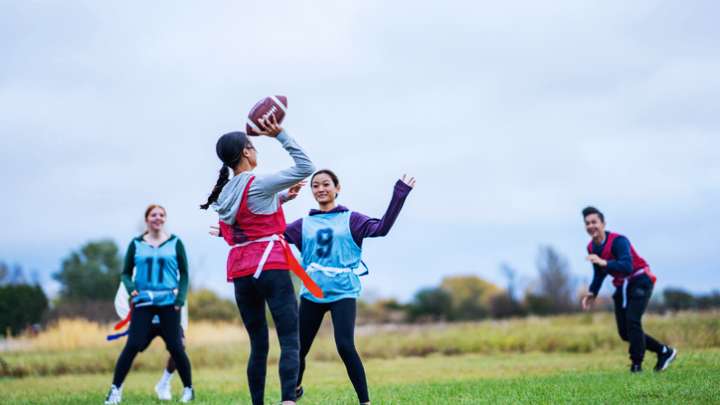 Women playing flag football on a field