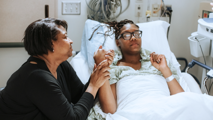 A photo of a mother comforting her daughter in the hospital