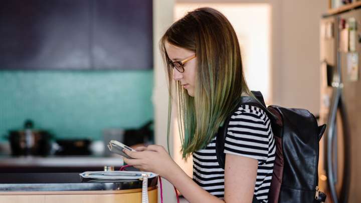 teenage girl looking at her phone