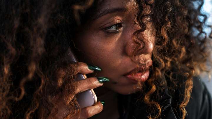 A closeup photo of a woman on a phone.
