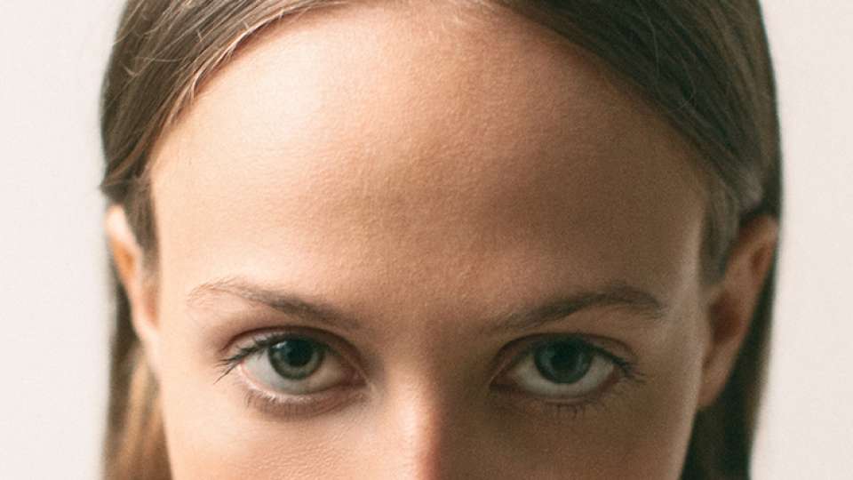 a zoomed in image of a young woman's forehead and eyes