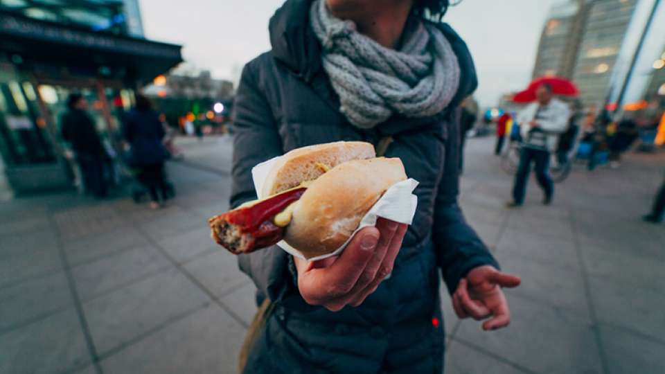 woman holding a hot dog while traveling