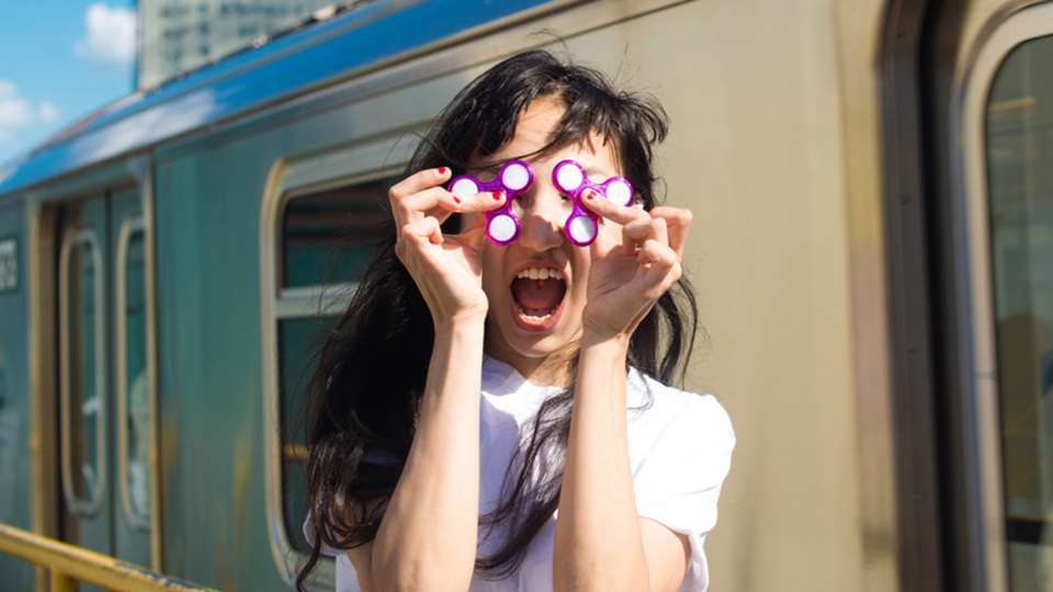 a young woman holding fidget spinners over her eyes