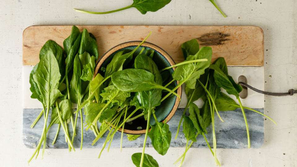 Raw spinach on cutting board