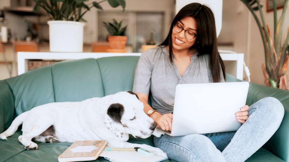 Woman on her computer cuddling with her dog