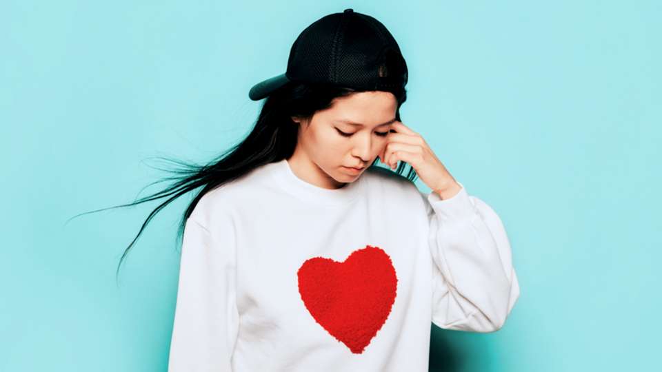 Woman wearing a sweatshirt with a heart on it.
