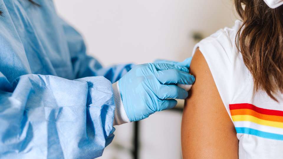 A closeup of a nurse's hands preparing a patient's arm for a vaccine.
