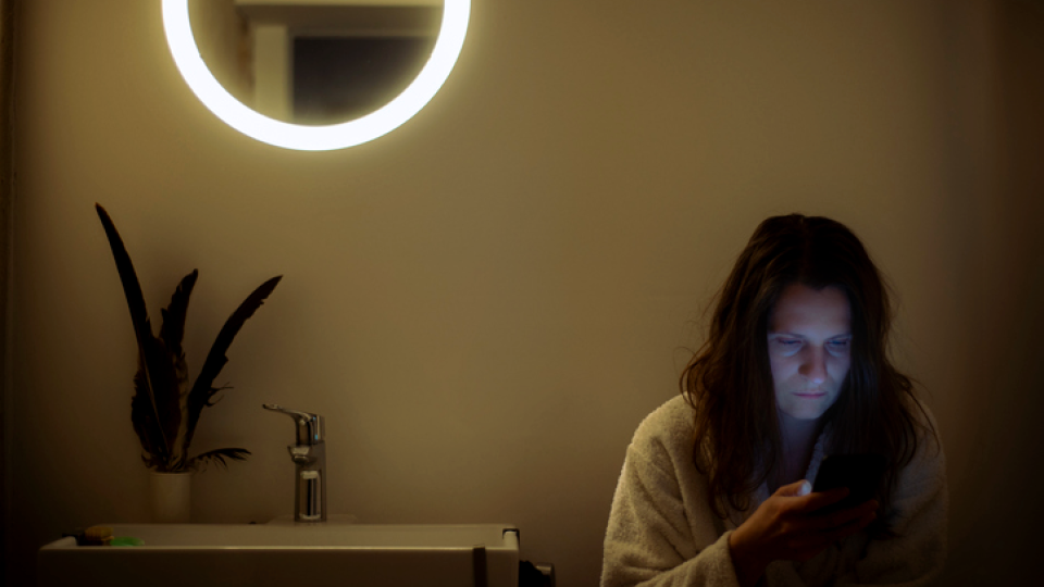 A woman in her bathroom at nighttime