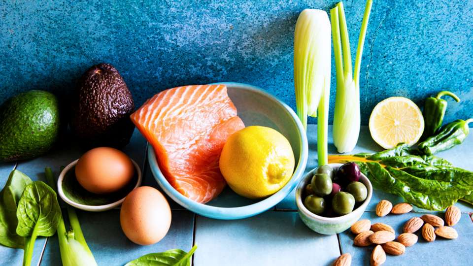 salmon, lemon and other healthy foods against blue background