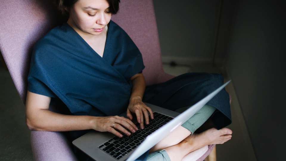 Woman sitting in a chair typing on a computer