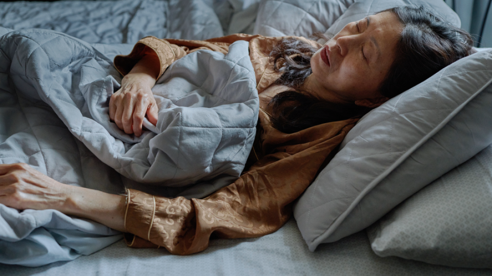 A middle aged woman sleeping in her bed