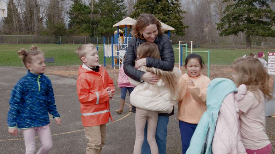 A photo of a teacher outside with her students