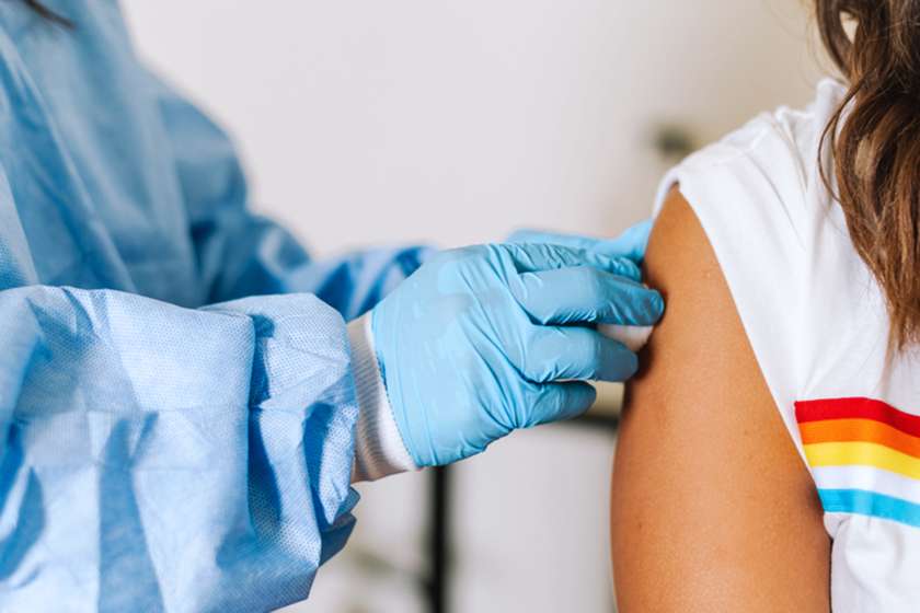 A closeup of a nurse's hands preparing a patient's arm for a vaccine.
