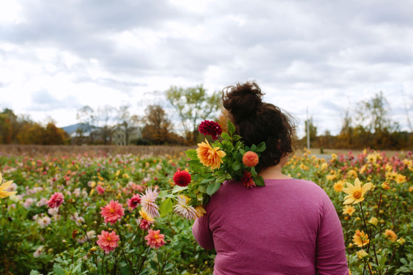 A photo of a woman in a field with flowers