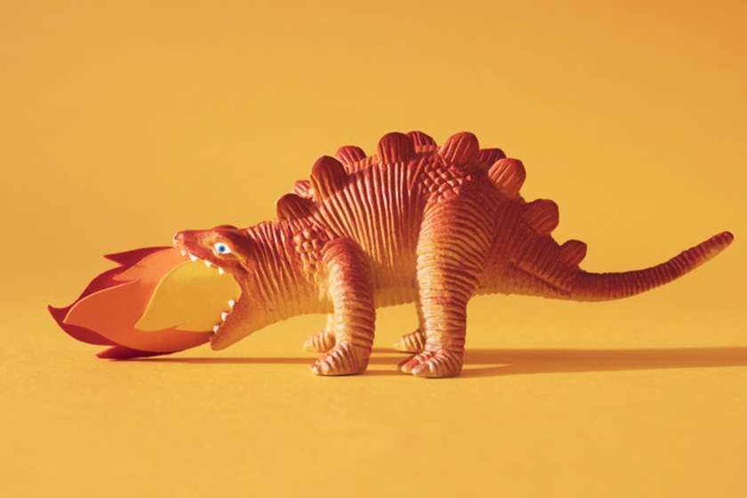 A toy dinosaur breathes fire.
