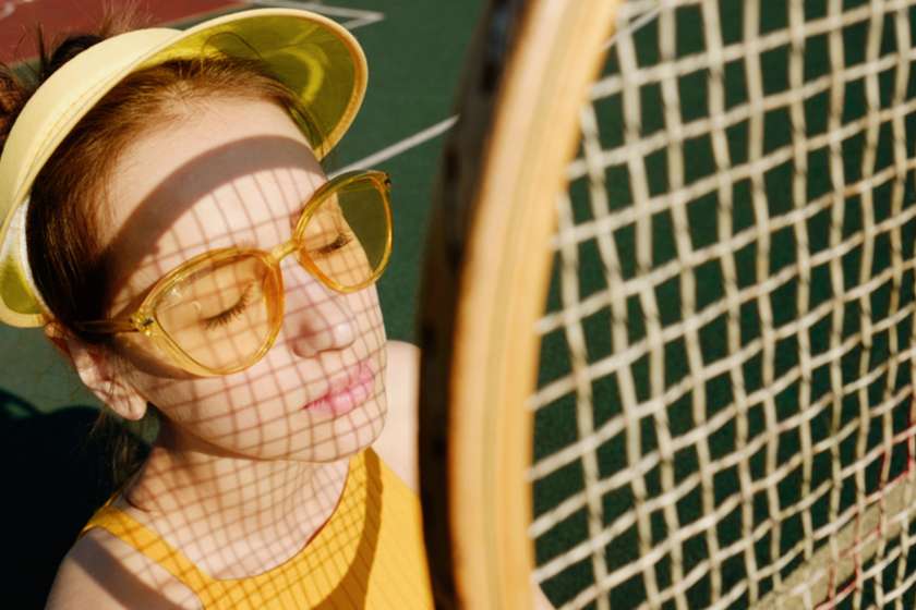 Woman in fun outfit playing tennis in the hot sun