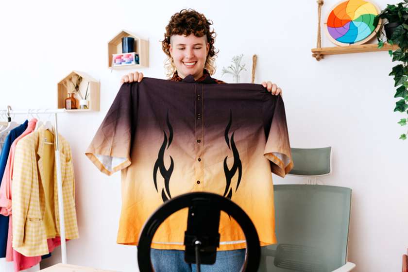 influencer holding up shirt with flames to show followers