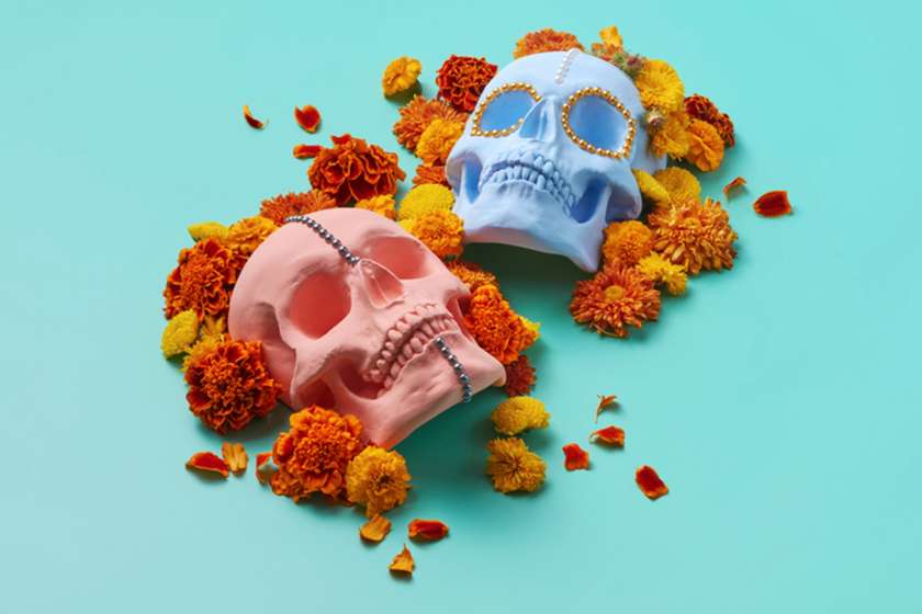 An illustration of pained skulls surrounded by marigolds.