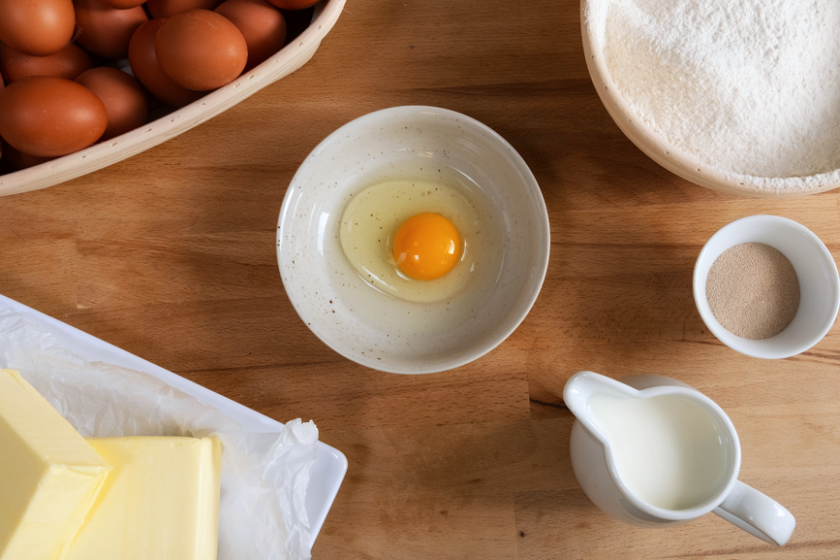 A photo of eggs, butter, and milk on a table