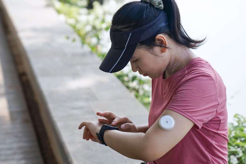 A woman checks her blood sugar reading on her smartwatch.