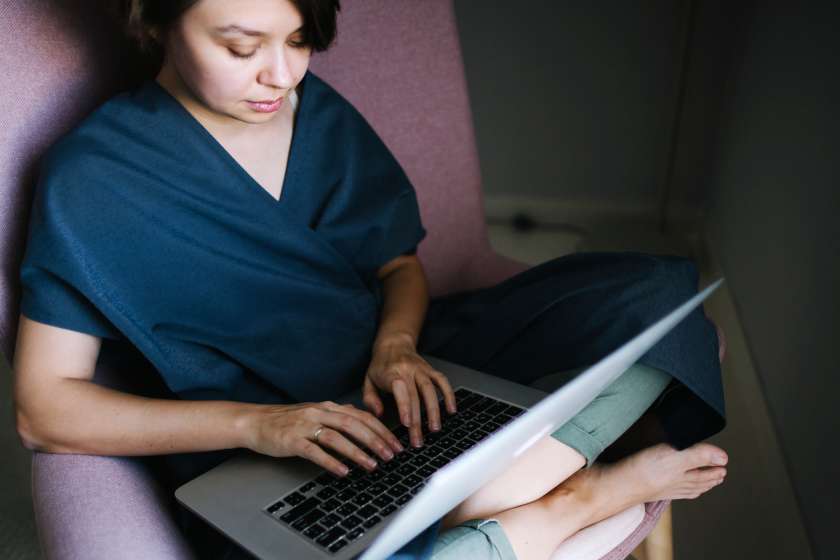 Woman sitting in a chair typing on a computer