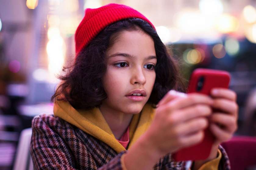 girl in red hat looking at her phone