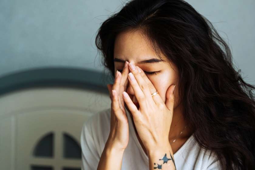 woman looking tired and rubbing her eyes