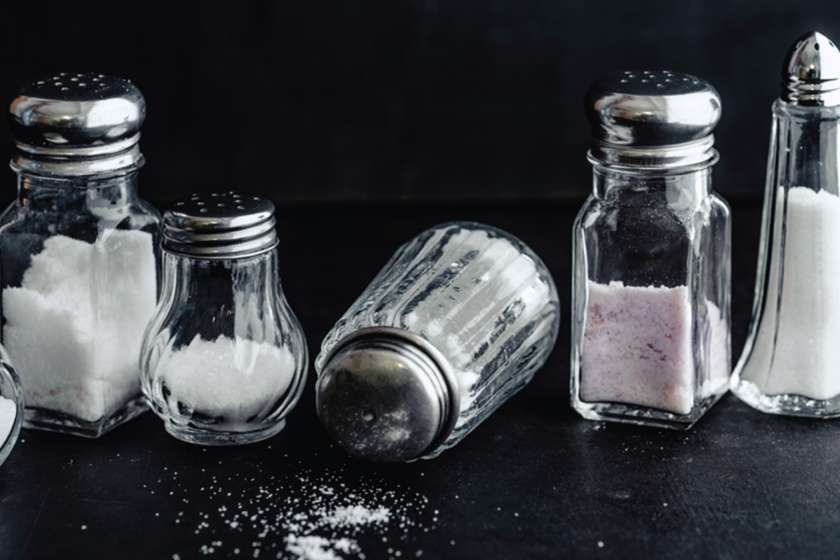 Different salt shakers against a dark background.