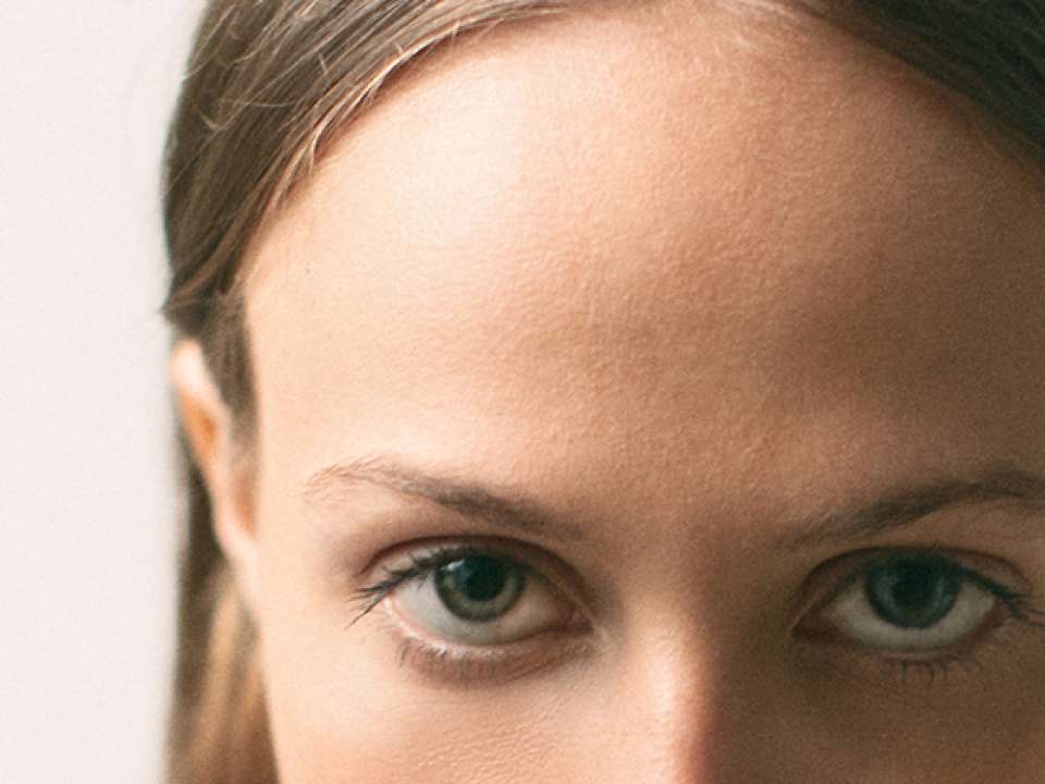 a zoomed in image of a young woman's forehead and eyes