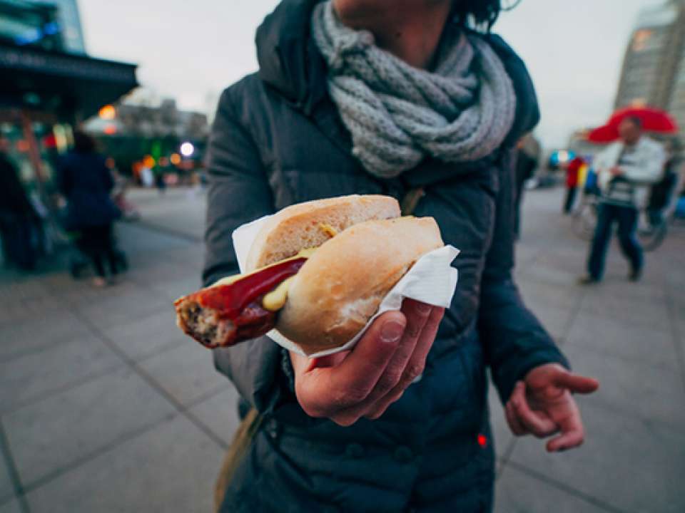 woman holding a hot dog while traveling