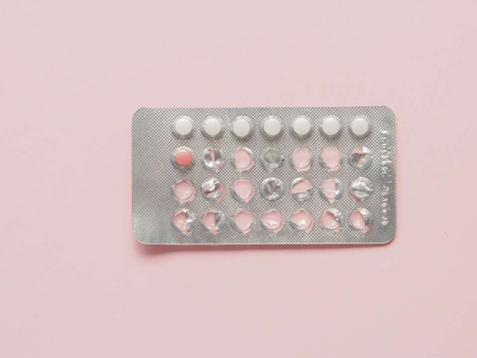 a birth control blister package with one pill left, over a pink background