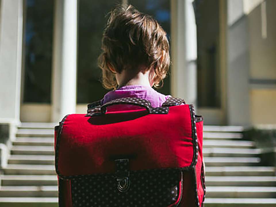 Child with red backpack on first day of school