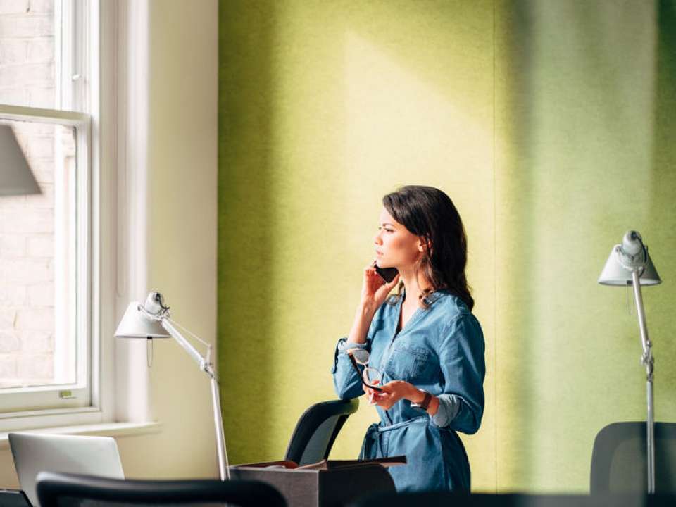 Woman in green office on telephone
