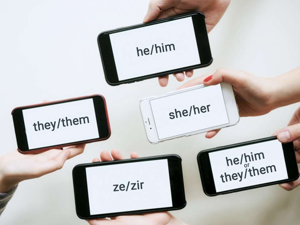 Hands hold phones that show different pronouns on the screens.