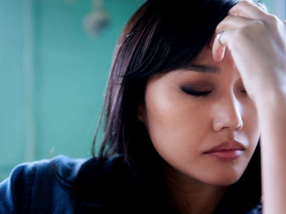 A woman touching her forehead