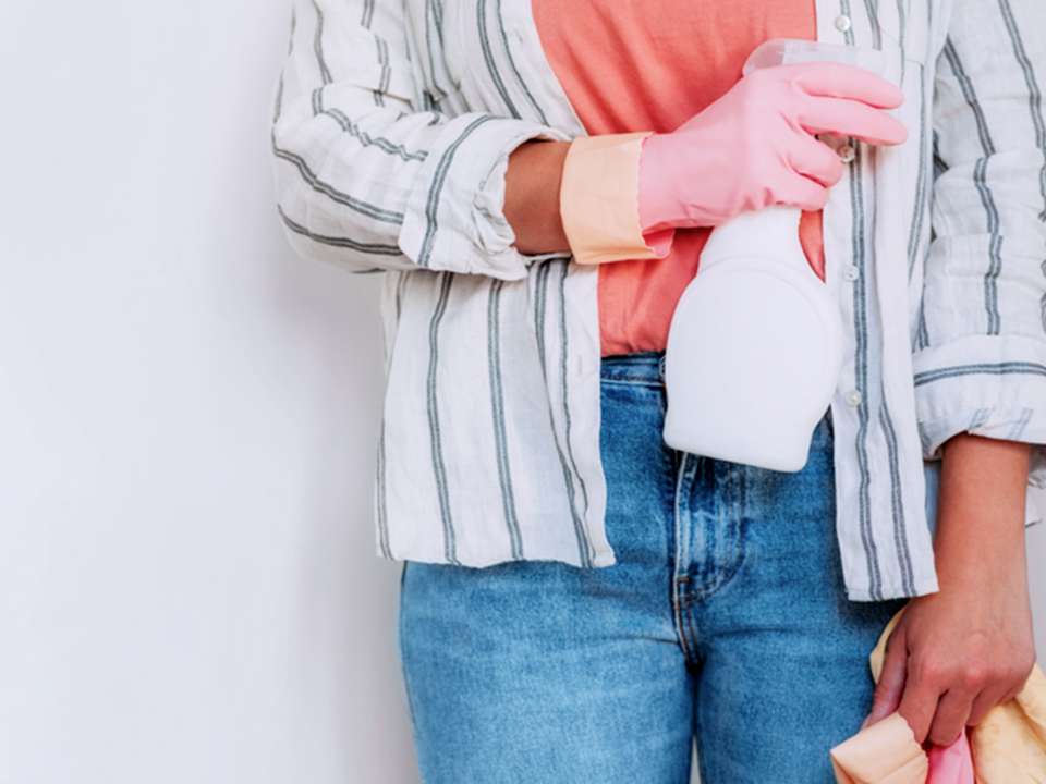 A person holds cleaning supplies.