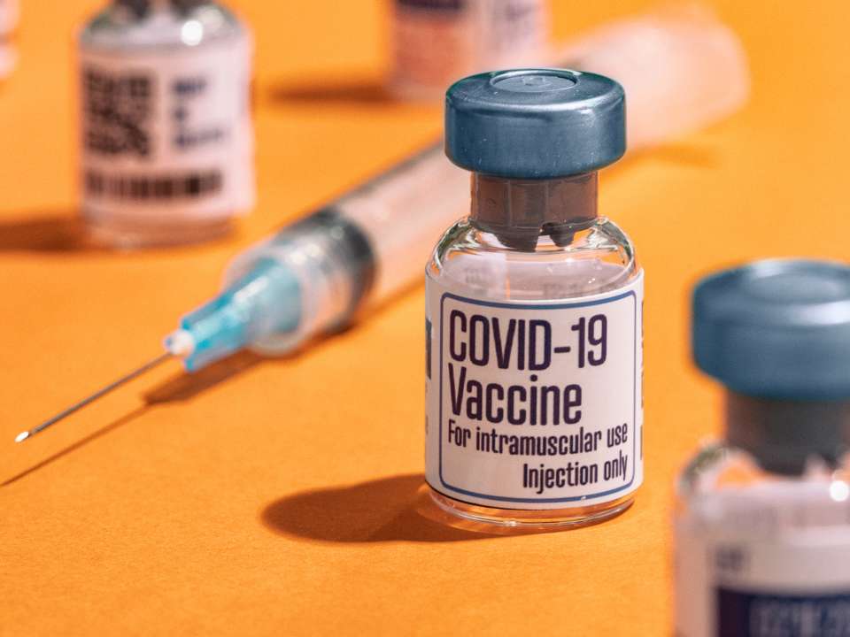 COVID-19 vaccine vials and a needle
