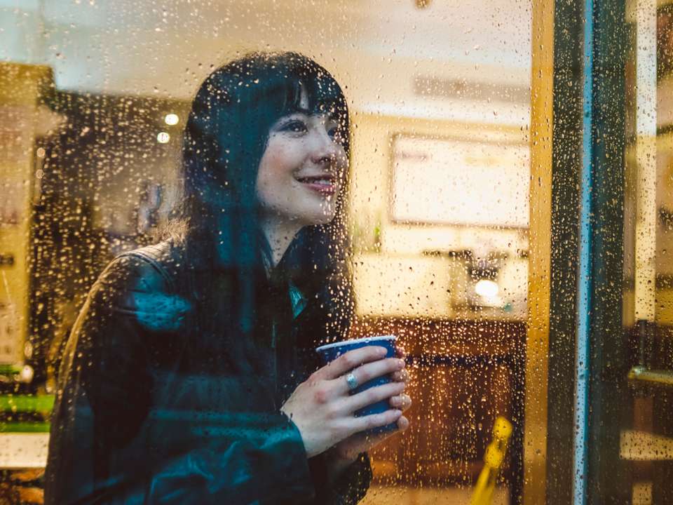 woman looking out window on a rainy day