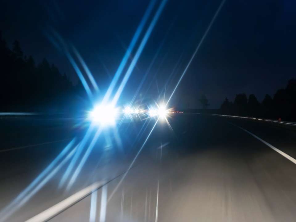 Blurry car headlights on road at night