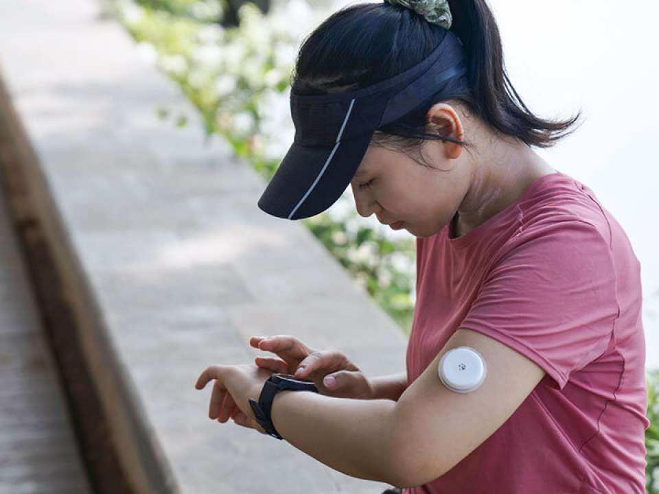 A woman checks her blood sugar reading on her smartwatch.