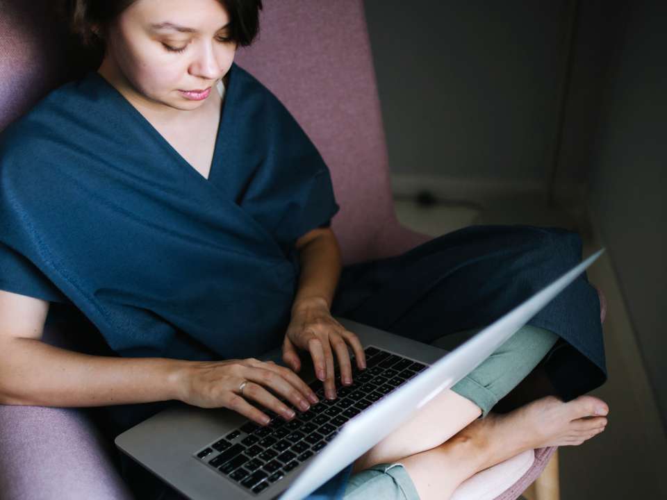 Woman sitting in a chair typing on a computer