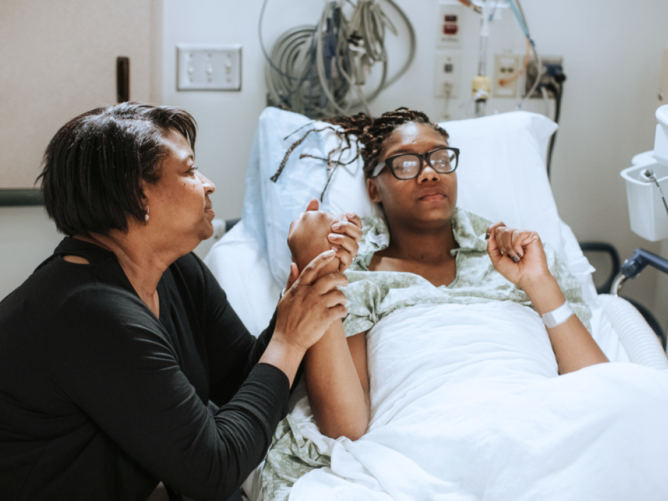 A photo of a mother comforting her daughter in the hospital