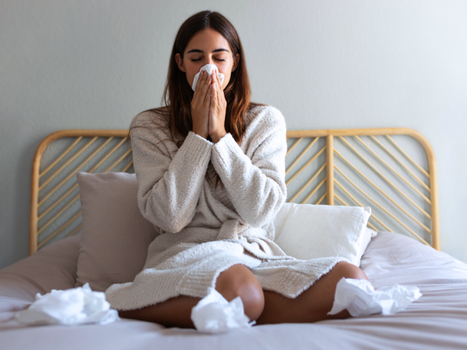 A photo of a woman on her bed with a cold