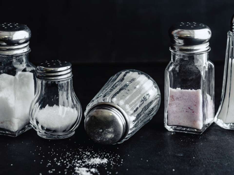 Different salt shakers against a dark background.